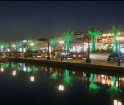a city lit up at night with green lights at Трёхкомнатная квартира in Sveti Vlas