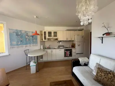 a living room with a couch and a kitchen at Sunny Seasons top view apartment SEA&POOL in Byala