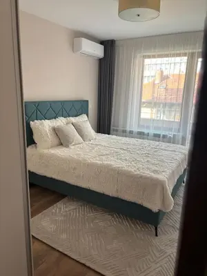 a bedroom with a bed and a window at Дизайнерски апартамент in Burgas City