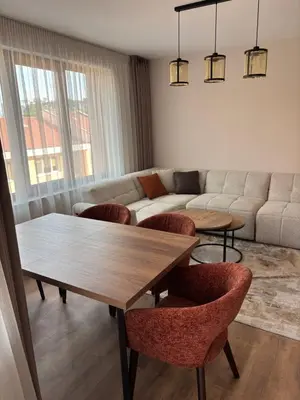 a living room with a table and chairs and a couch at Дизайнерски апартамент in Burgas City