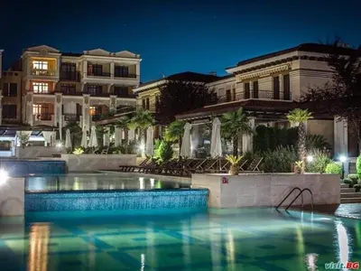 a swimming pool in front of a building at night at Green life private garden studio in Sozopol