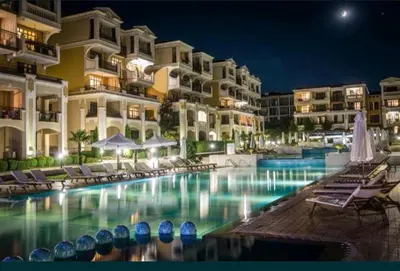 a swimming pool in front of a hotel at night at Green life private garden studio in Sozopol