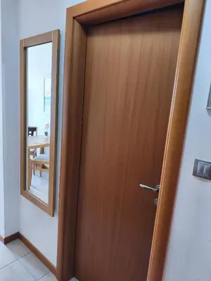a wooden door in a room with a mirror at Emerald Apartman Wellness & Spa in Ravda
