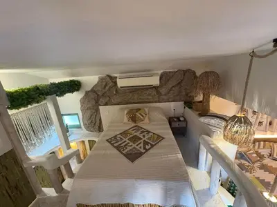 a room with a bed and a table and chairs at Flores Gardan ART Studio in Chernomorets