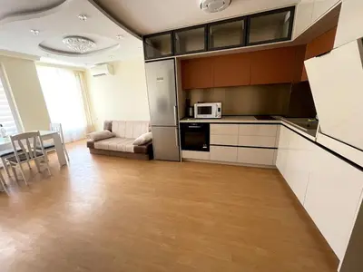 a kitchen and living room with a couch and a microwave at 2BR Garden Bay Apartment in Varna City