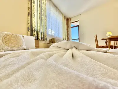 a bedroom with a white bed with a window at Sunny Sea - Menada Apartments in Sunny Beach