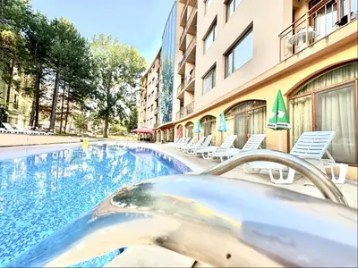 a swimming pool with a hot tub in front of a building at Sunny Sea - Menada Apartments in Sunny Beach