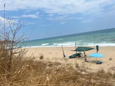 a couple of umbrellas on a beach with the ocean at Палатка на Кара Дере in Byala