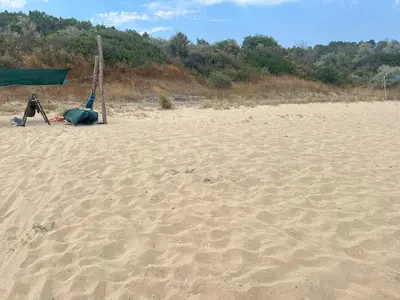 a person standing on a beach with a tent at Палатка на Кара Дере in Byala