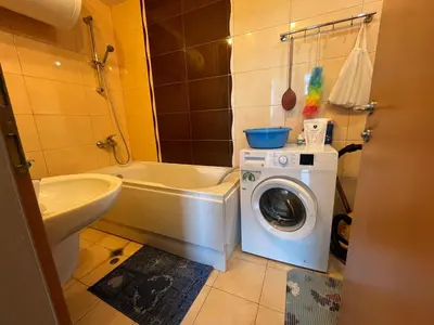 a bathroom with a washing machine and a toilet at 2-bedroom Apartment in Marina Holiday Club Pomorie in Pomorie