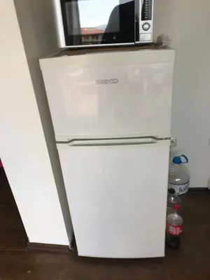 a white refrigerator with a microwave on top of it at Terasa Ravda apart in Ravda
