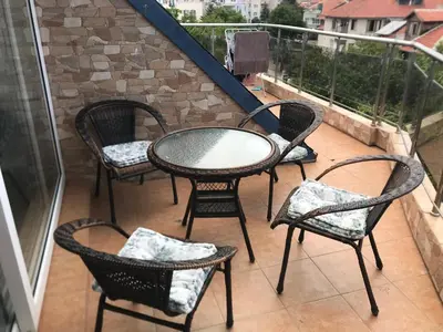 a patio with four chairs and a table on a balcony at Terasa Ravda apart in Ravda