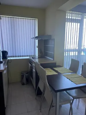 a kitchen with a table and chairs in a room at Private 2-Bedroom Apartment with Pool and Free Parking in Marina Holiday Club Pomorie in Pomorie