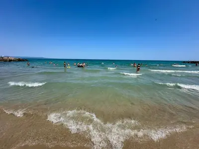 a group of people in the water at the beach at Sunrise Apartment in Pomorie