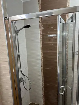 a shower in a bathroom with a glass door at Sunrise Apartment in Pomorie