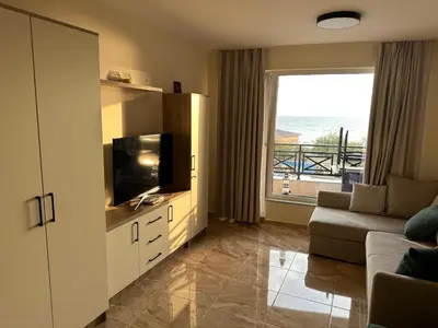 a living room with a couch and a flat screen tv at Sunrise Apartment in Pomorie