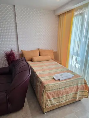 a small bedroom with a bed and a couch at Apartment Miramar Palace in Sunny Beach