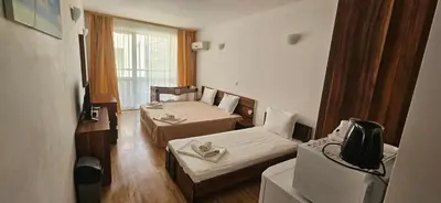 a small room with two beds and a tv at Библиотеката in Pomorie