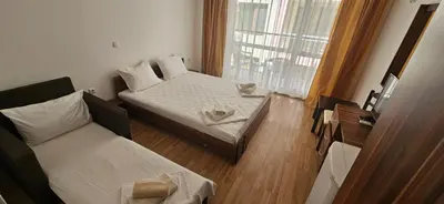 a small room with two beds and a window at Библиотеката in Pomorie