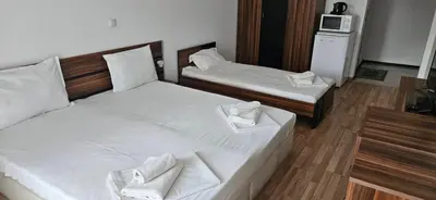 two twin beds in a room with a microwave at Библиотеката in Pomorie