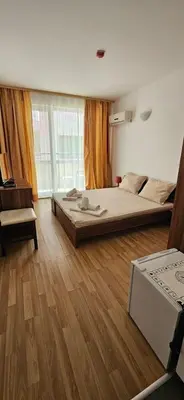 a bedroom with two beds and a wooden floor at Библиотеката in Pomorie