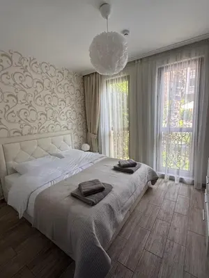 a bedroom with a large bed and a chandelier at Boho apartament Cascadas family in Sunny Beach
