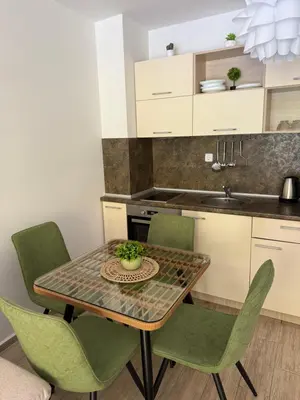 a kitchen with a table and chairs and a sink at Boho apartament Cascadas family in Sunny Beach