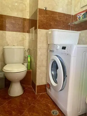 a bathroom with a washing machine and a toilet at Peaceful, Top Floor, 2 Bedroom in Sunny Beach