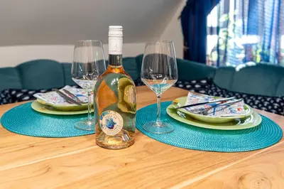 a bottle of wine sitting on a table with two glasses at Afala Loft & Terrase - Heart of Burgas in Burgas City