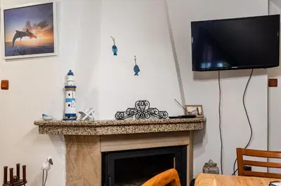 a living room with a fireplace with a flat screen tv at Afala Loft & Terrase - Heart of Burgas in Burgas City