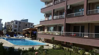 a building with a swimming pool next to a building at Anfid Apartments in Burgas City