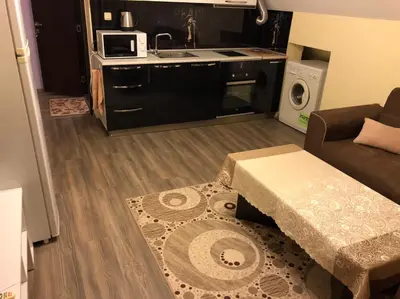 a living room with a couch and a kitchen at Anfid Apartments in Burgas City