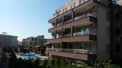 a building with a swimming pool in front of it at Anfid Apartments in Burgas City