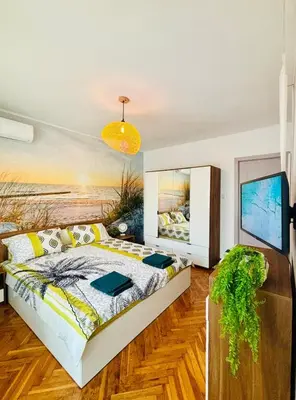 a bedroom with a bed and a painting on the wall at Sea Breeze in Burgas City