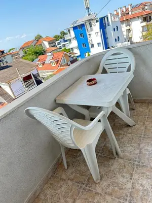 a table and chair on a balcony with a view at Хотел Модева in Chernomorets