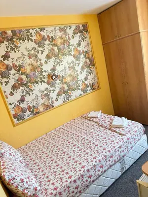 a bedroom with a bed with a flower picture on the wall at Хотел Модева in Chernomorets