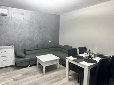 a living room with a green couch and a table at Апартамент Велкови in Tsarevo