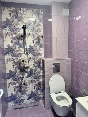 a bathroom with a toilet with a flower wallpaper at Апартамент Велкови in Tsarevo