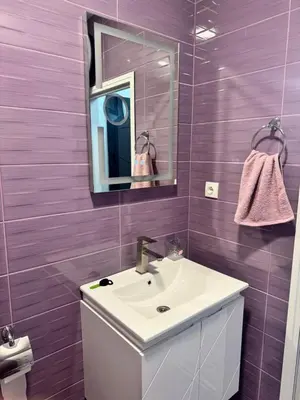 a bathroom with a white sink and a mirror at Апартамент Велкови in Tsarevo