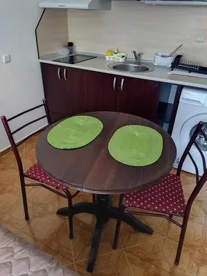 a wooden table with two green plates on it in a kitchen at Святая Елена in Sunny Beach