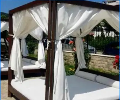 a canopy bed with white drapes on it at Luxury Coastal Dreams Apartment in Sveti Vlas