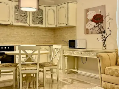 a kitchen with white cabinets and a table with a microwave at Luxury Coastal Dreams Apartment in Sveti Vlas