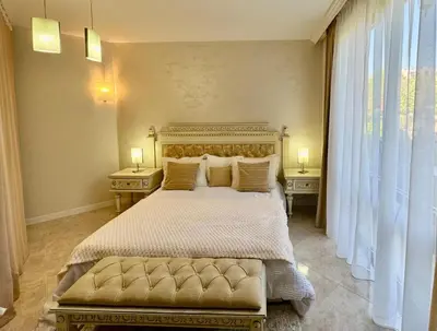 a bedroom with a large bed with two tables and two lamps at Luxury Coastal Dreams Apartment in Sveti Vlas