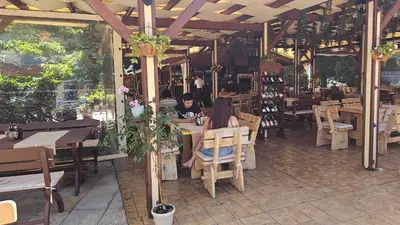 two people sitting at tables in a restaurant at Apartment 16 - Rainbow Holiday Complex in Sunny Beach