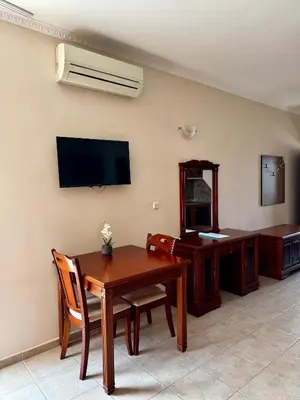 a room with a table and a desk and a television at Sea View Apartment Sveti Vlas in Sveti Vlas