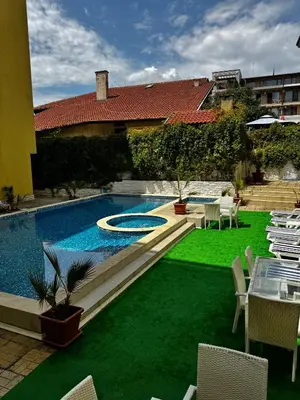 a backyard with a swimming pool and green grass at Sea View Apartment Sveti Vlas in Sveti Vlas