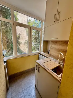 a kitchen with two windows and a counter top at Beach Please Apartment in Burgas City
