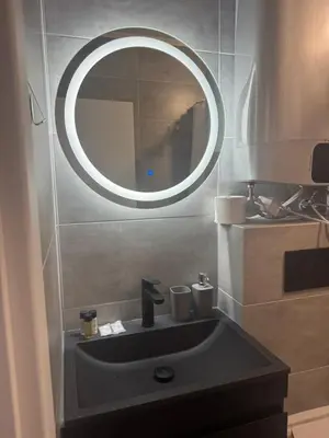 a bathroom sink with a round mirror above it at Апартаменти в Созопол, Каваци- Север in Sozopol