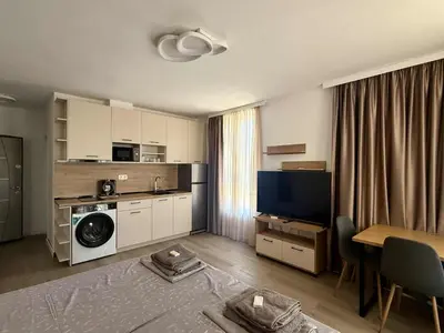 a living room with a kitchen and a room with a table at Апартаменти в Созопол, Каваци- Север in Sozopol