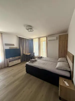 a bedroom with a large bed and a table at Апартаменти в Созопол, Каваци- Север in Sozopol
